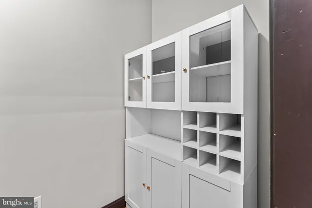 a view of a living room with kitchen furniture and a ceiling fan