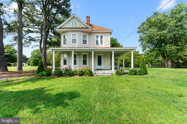 a front view of a house with a yard and trees