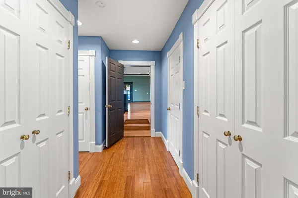 a view of a hallway with wooden floor and staircase