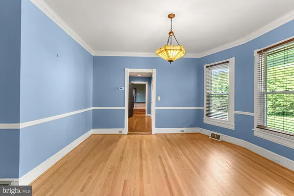 a view of empty room with a window and wooden floor