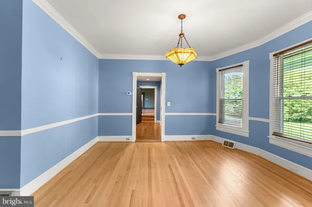a view of empty room with a window and wooden floor