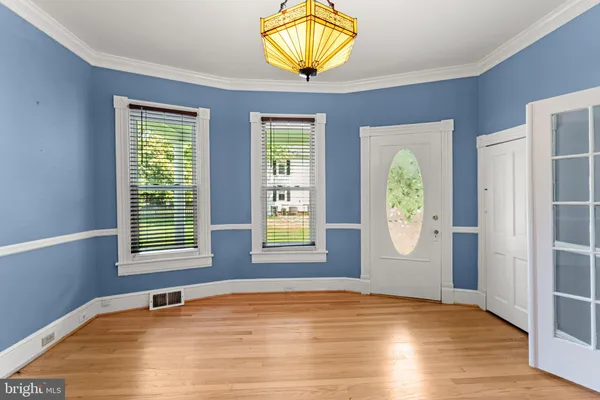 a view of an empty room with window and wooden floor