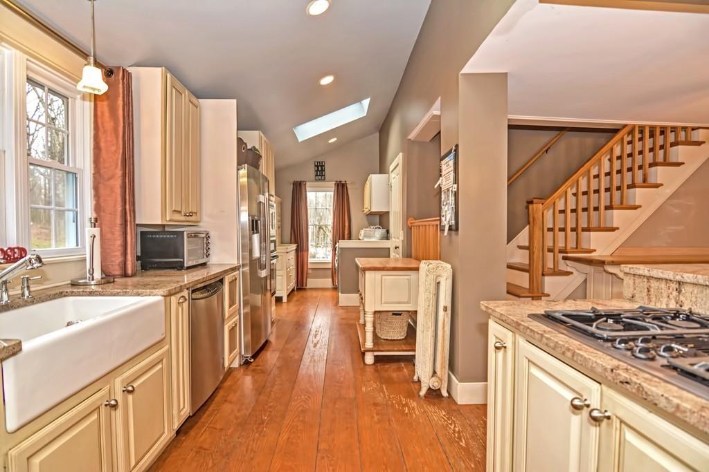 50 Warren Road Brimfield, MA 01010 - Photo 7 of 42 a kitchen with stainless steel appliances a stove a sink dishwasher and a dining table with wooden floor
