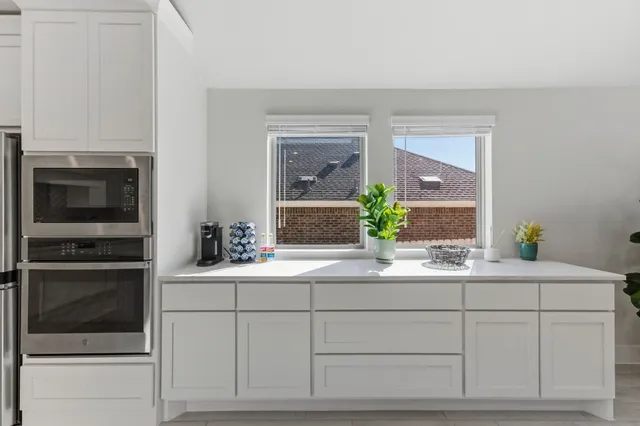 a kitchen with a table chairs refrigerator and cabinets