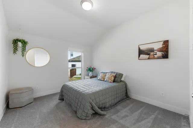 a view of an empty room with window and a kitchen