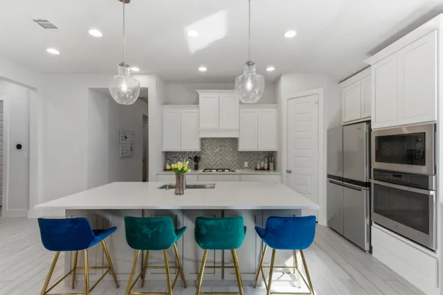 a kitchen with kitchen island granite countertop a sink and stainless steel appliances