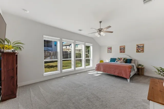 a spacious bedroom with a bed and a window