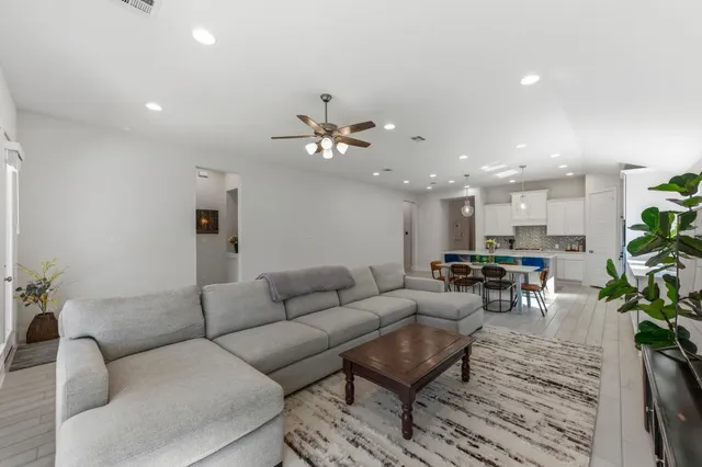 a living room with furniture kitchen view and a potted plant