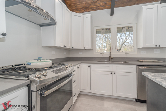 44 Old Creek Road Palos Park, IL 60464 - Photo 9 of 38 a kitchen with a stove and white cabinets