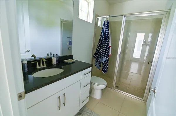 a kitchen with a sink a stove a refrigerator and white cabinets with wooden floor