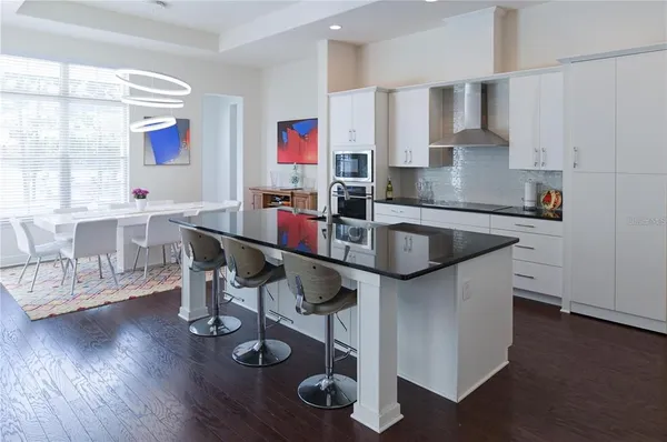 a dining table with a stove and wooden floor