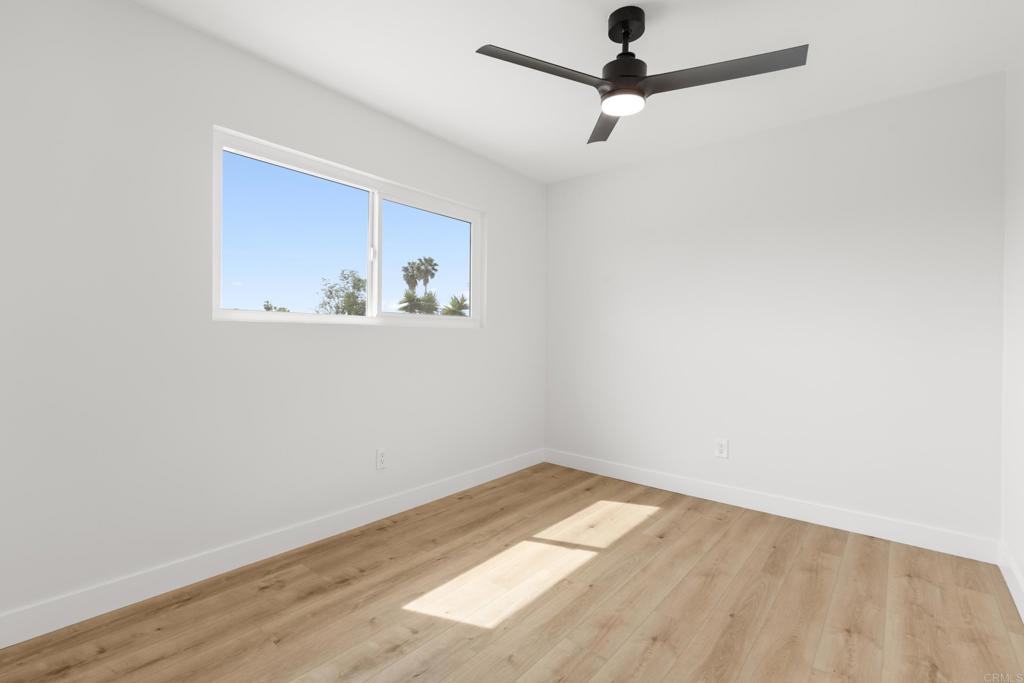 4907 Stephanie Place Oceanside, CA 92057 - Photo 15 of 24 an empty room with a window and a ceiling fan