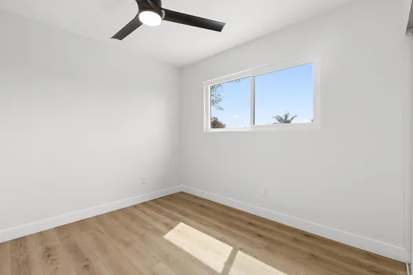 a view of a room with wooden floor and white walls