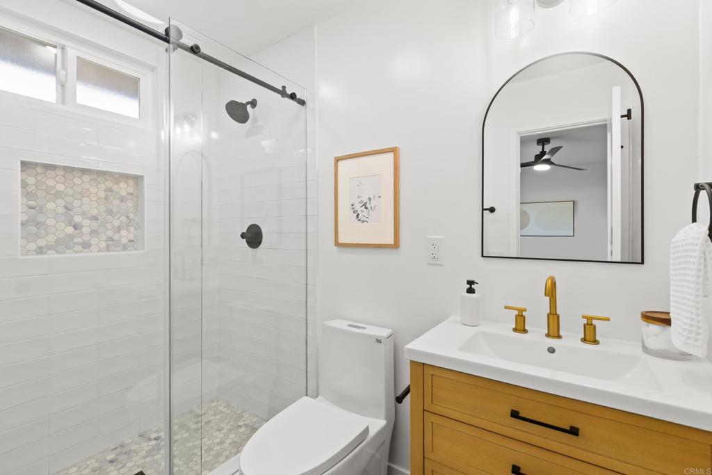 4907 Stephanie Place Oceanside, CA 92057 - Photo 18 of 24 a bathroom with a granite countertop sink mirror vanity and toilet
