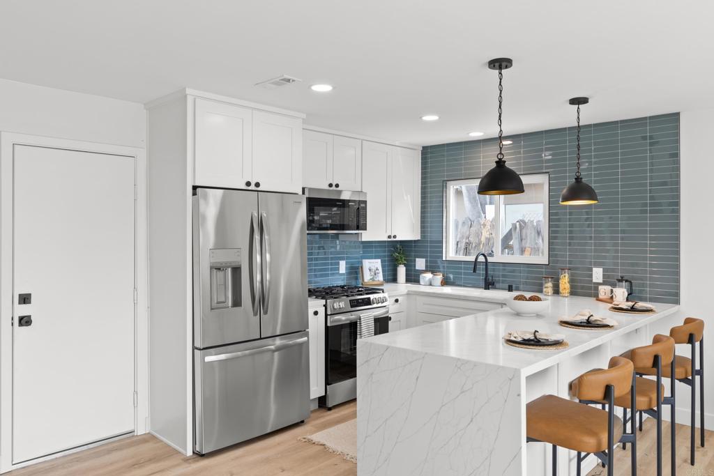 4907 Stephanie Place Oceanside, CA 92057 - Photo 6 of 24 a kitchen with kitchen island a sink appliances and cabinets