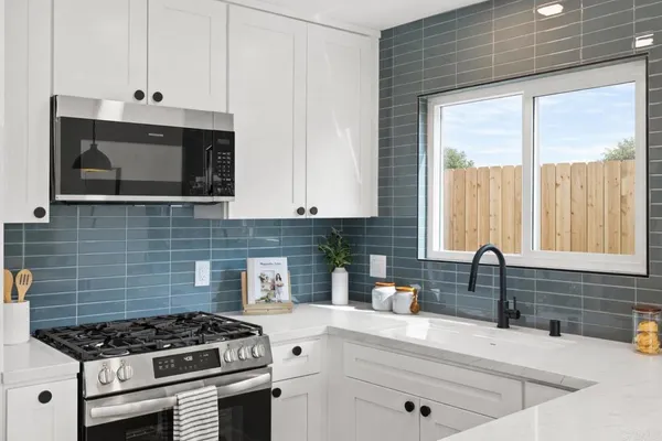 a kitchen with stainless steel appliances a stove sink and cabinets