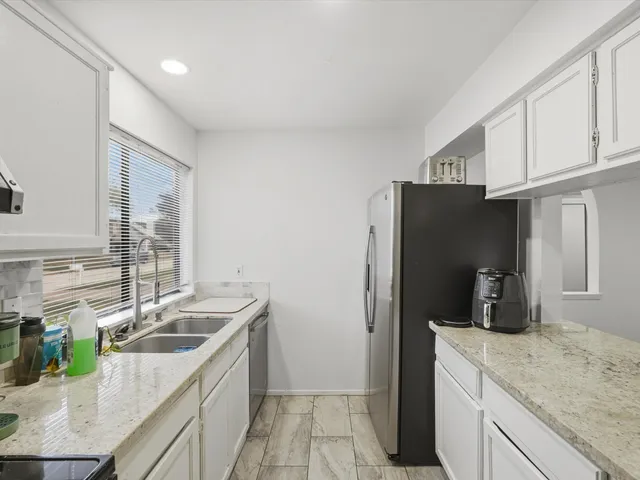 a kitchen that has a sink cabinets counter space and appliances