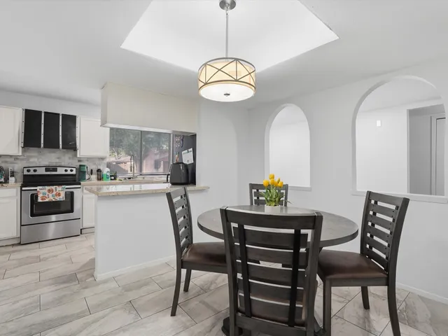 a dining room with wooden floor a chandelier a wooden table and chairs