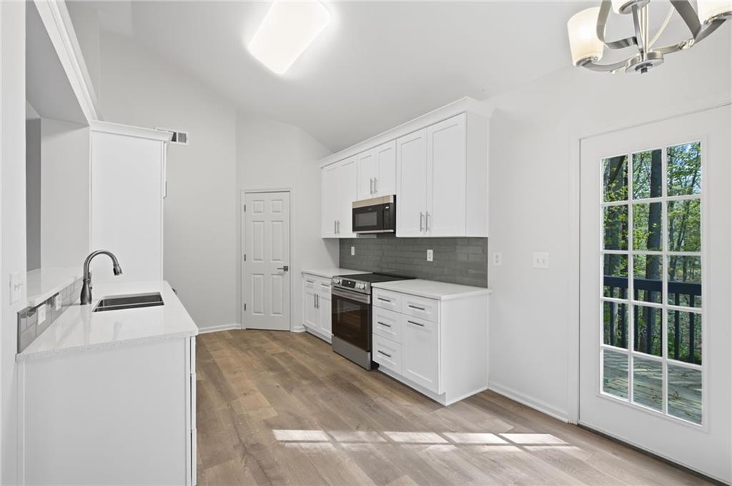 9485 Waldrip Road Gainesville, GA 30506 - Photo 6 of 30 a kitchen with sink a microwave and refrigerator
