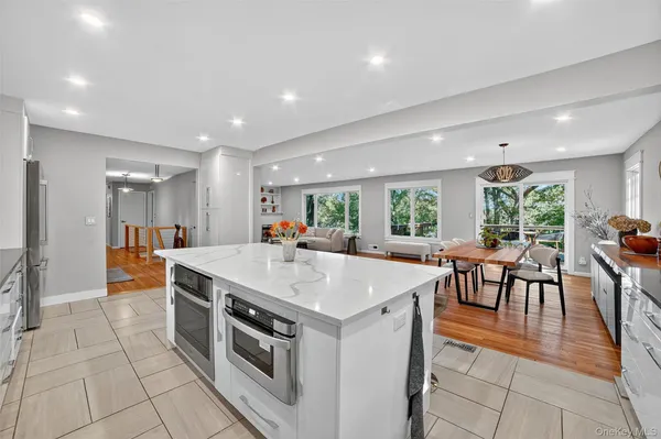 a large kitchen with stainless steel appliances granite countertop a stove a sink a dining table and chairs