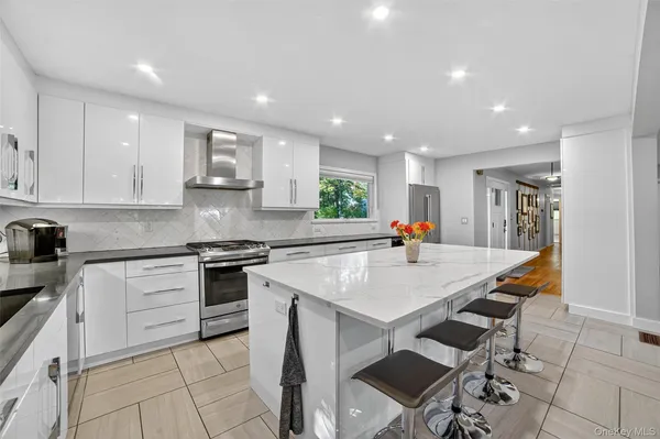 a kitchen with stainless steel appliances a table and chairs in it