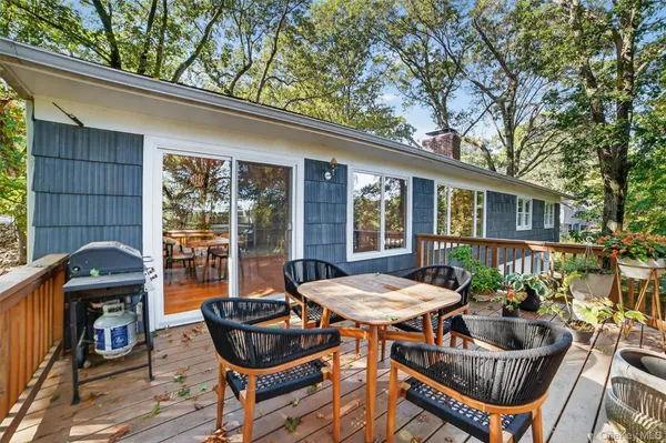 a balcony with wooden floor table and chairs