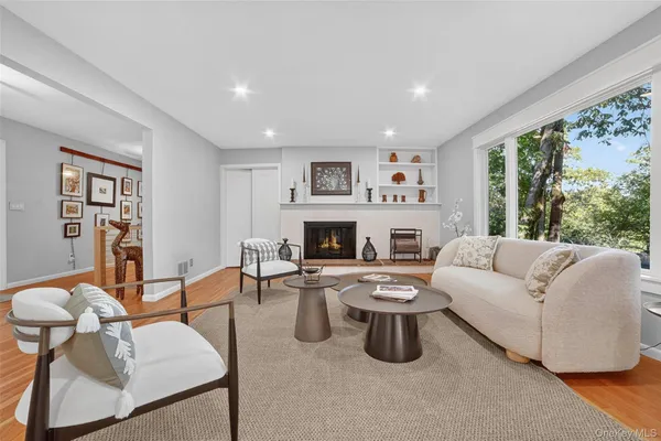 a living room with furniture fireplace and a large window