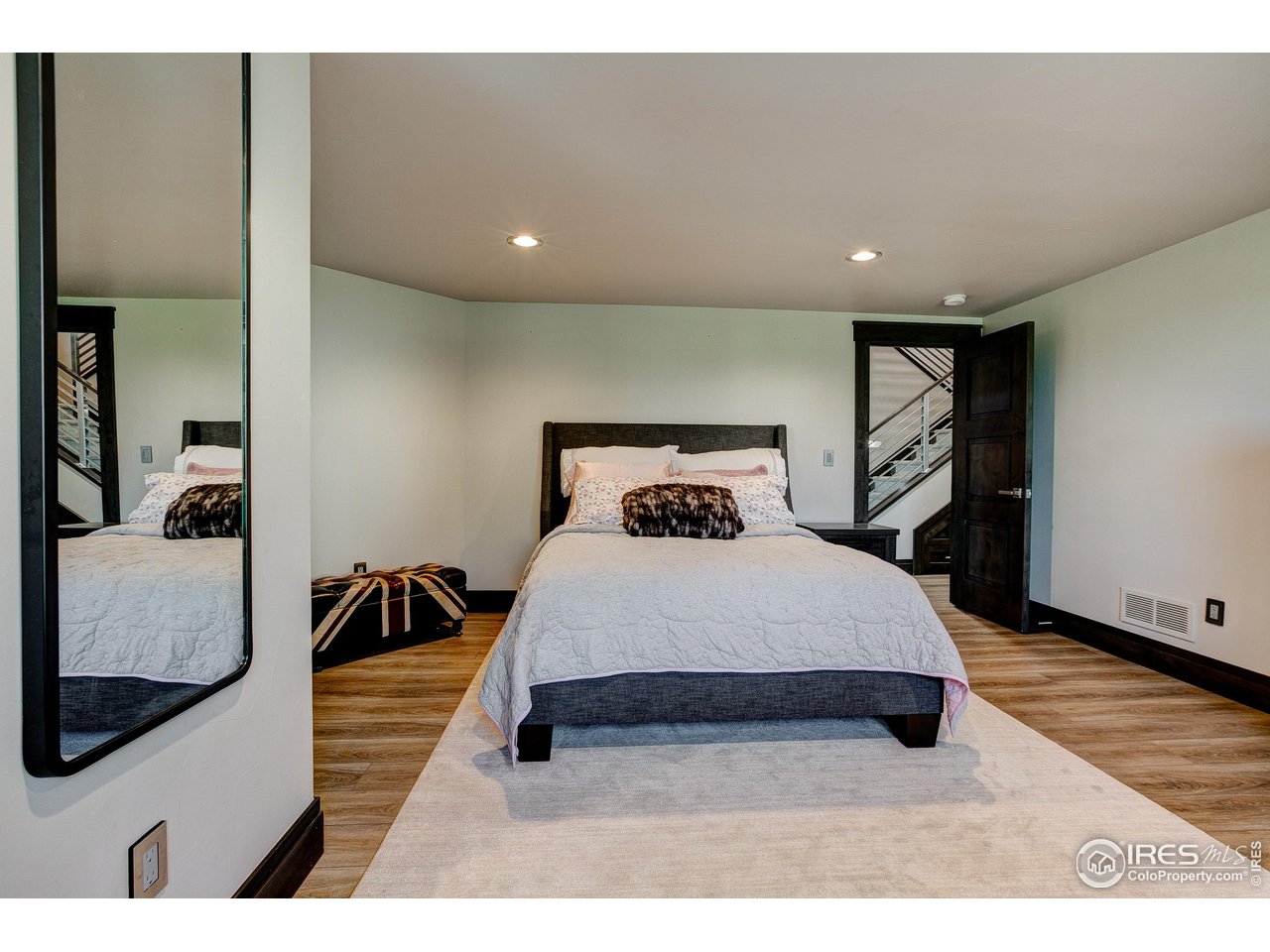 6438 Sanctuary Drive Windsor, CO 80550 - Photo 32 of 40 a spacious bedroom with a bed and a view of living room