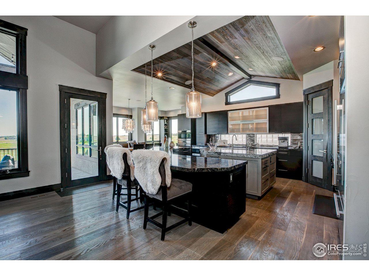 6438 Sanctuary Drive Windsor, CO 80550 - Photo 8 of 40 a dining hall with stainless steel appliances granite countertop a sink dishwasher a dining table and chairs with wooden floor