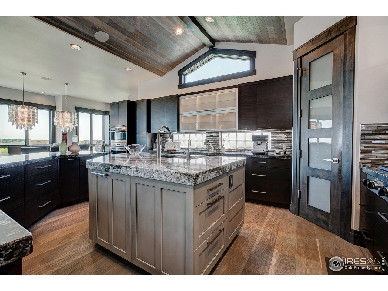 6438 Sanctuary Drive Windsor, CO 80550 - Photo 9 of 40 a kitchen with stainless steel appliances granite countertop a stove a sink and a refrigerator