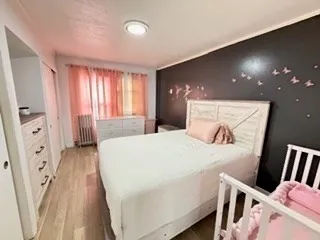 a spacious bedroom with a bed and wooden floor