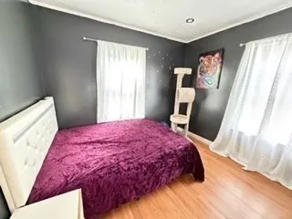 a bedroom with a bed and wooden floor