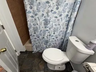 a white toilet sitting next to a small bathroom