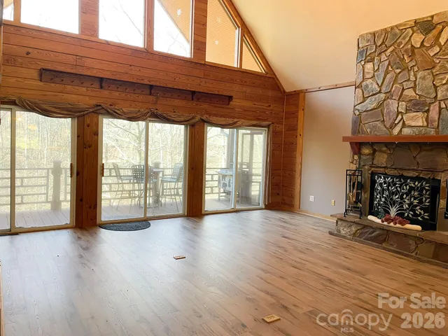 a view of empty room with a fireplace and wooden floor