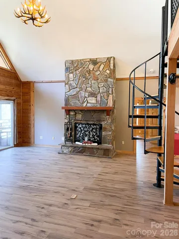 a view of empty room with a fireplace and wooden floor