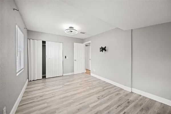 a view of empty room with wooden floor