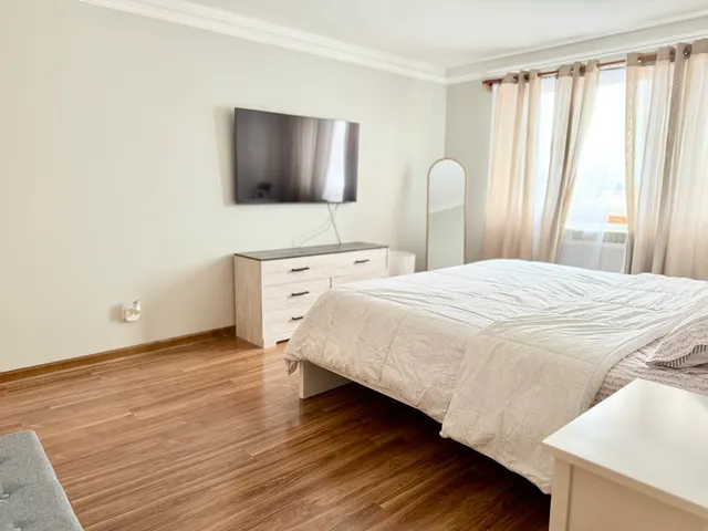 a bedroom with a bed and a flat screen tv