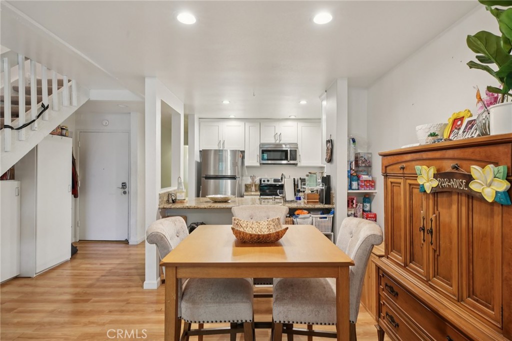 7890 East Spring Street, Unit 16P Long Beach, CA 90815 - Photo 5 of 25 a view of a dining room with furniture and wooden floor