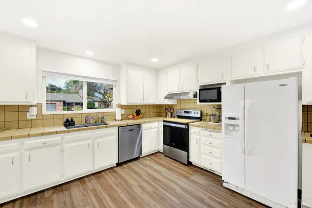 a kitchen with granite countertop a stove top oven and cabinets