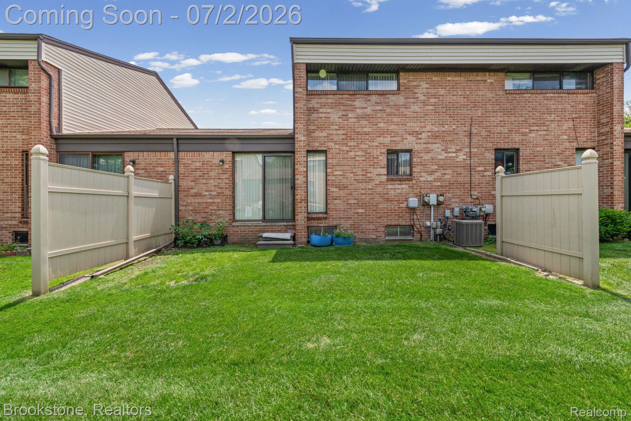 1925 Nicholas Court Warren, MI 48092 - Photo 25 of 26 Private outdoor space with manicured lawn, brick exterior, vinyl privacy fencing, and sliding glass door access