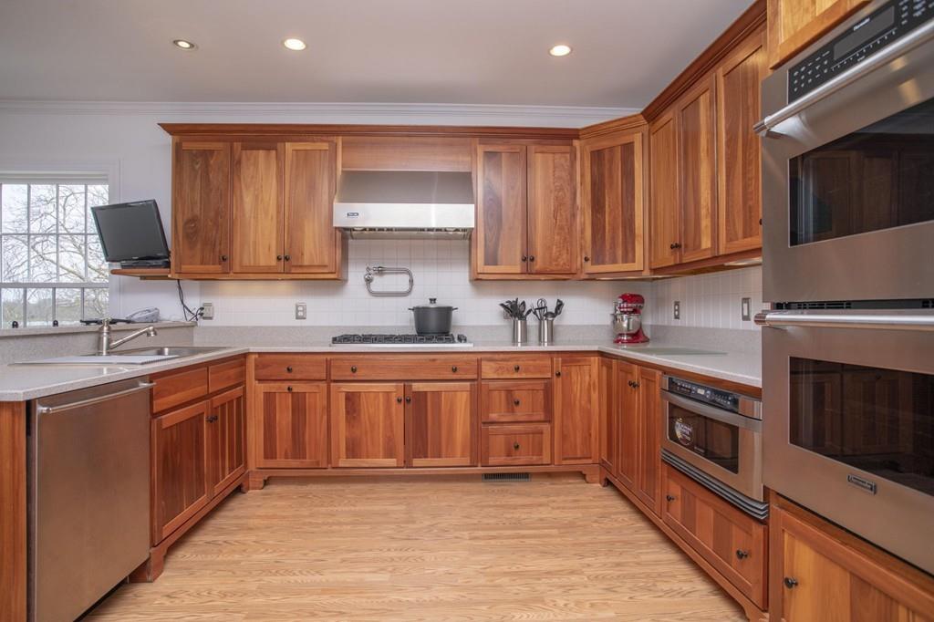 922 Drift Road Westport, MA 02790 - Photo 24 of 42 a kitchen with stainless steel appliances granite countertop a stove top oven a sink dishwasher and a microwave oven with wooden cabinets