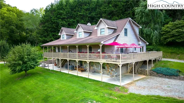 a view of house with a big yard and potted plants