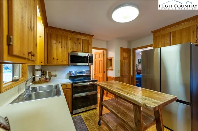 a kitchen with stainless steel appliances a refrigerator and a stove top oven