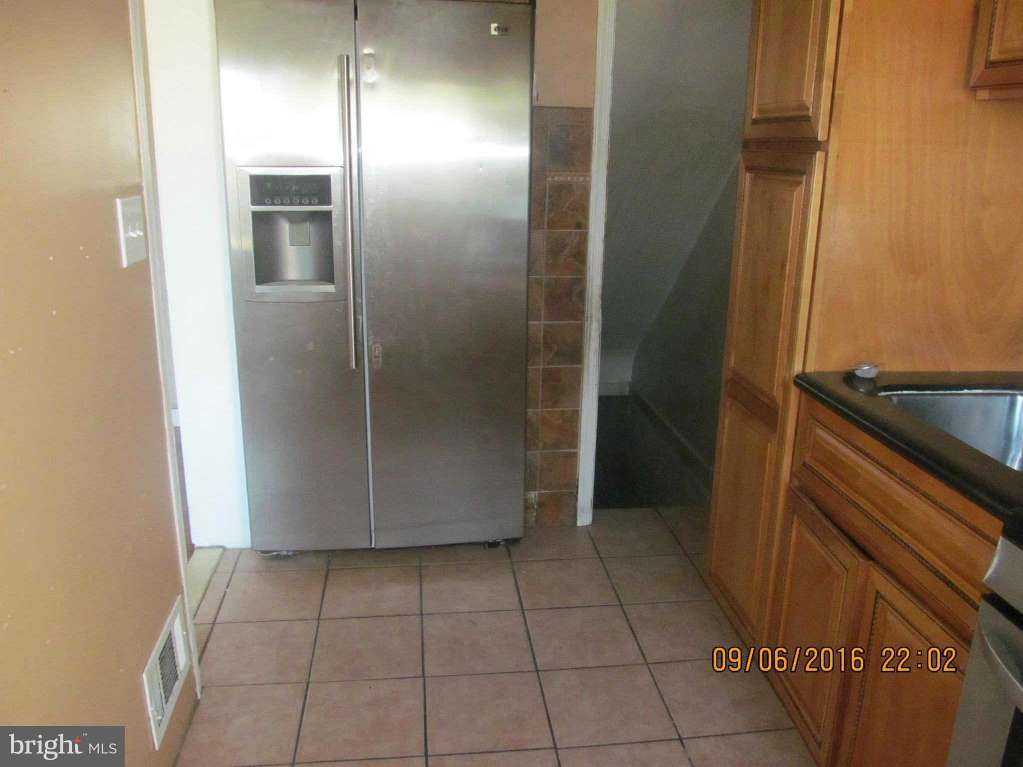 2106 Redthorn Road Baltimore, MD 21220 - Photo 5 of 13 a view of a refrigerator in kitchen and an empty room