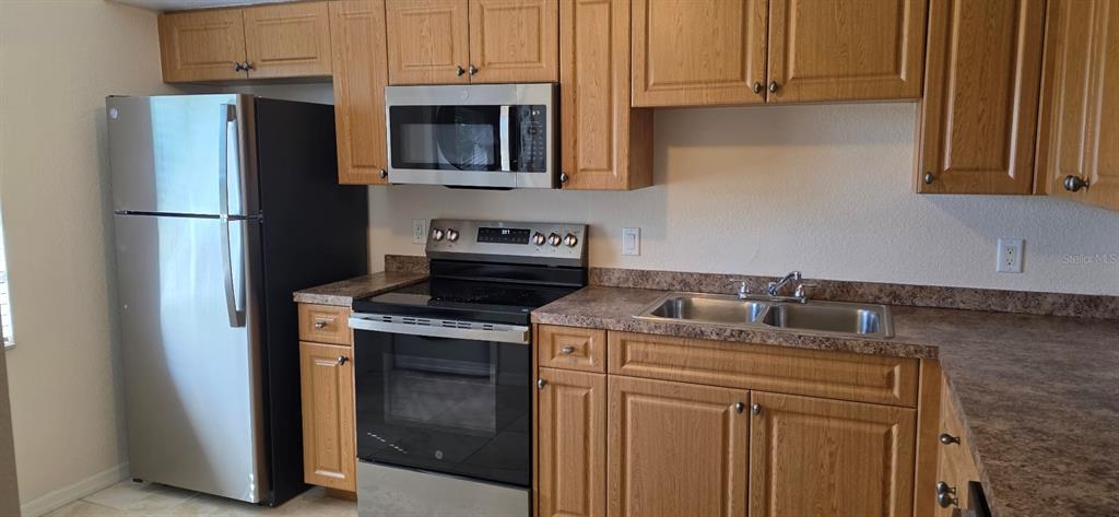 26201 Explorer Road, Unit 5 Punta Gorda, FL 33983 - Photo 5 of 11 a kitchen with stainless steel appliances granite countertop a refrigerator stove a sink and dishwasher