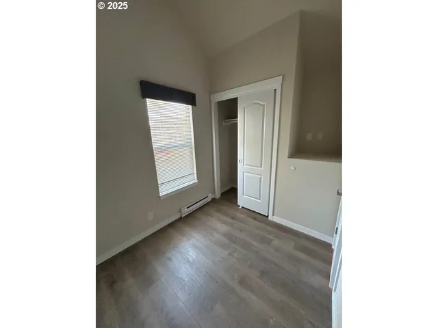 a view of an empty room with wooden floor