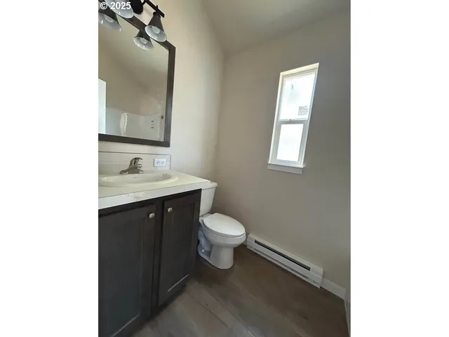 a bathroom with a toilet a sink and mirror