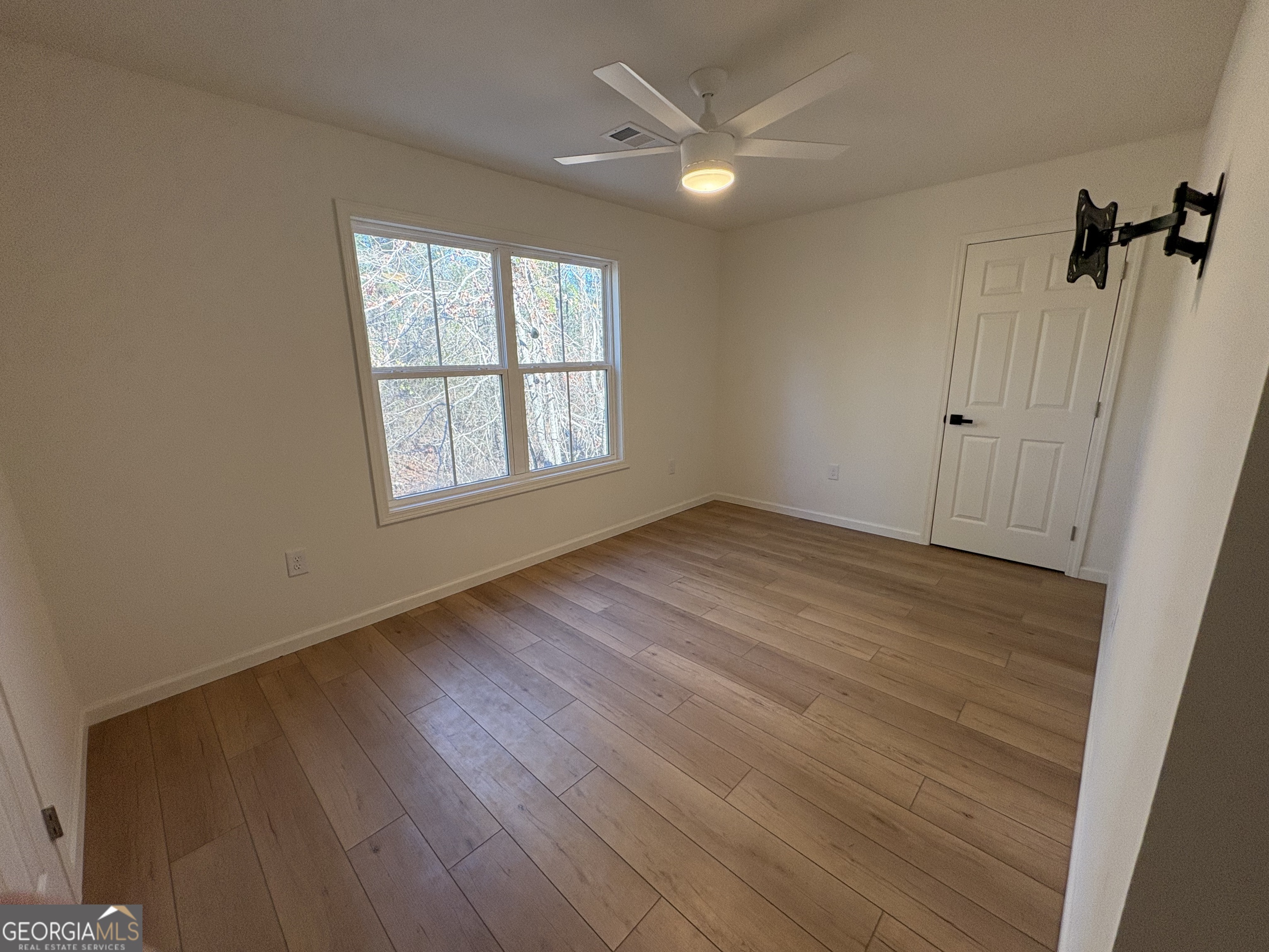 435 Muskogee Trail Dublin, GA 31021 - Photo 26 of 31 an empty room with wooden floor fan and windows