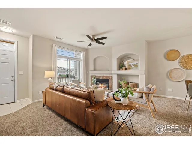 a living room with furniture a fireplace and a large window