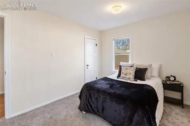 a bedroom with a bed and painting on the wall